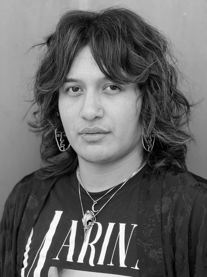 A black and white photo of a person with long hair.