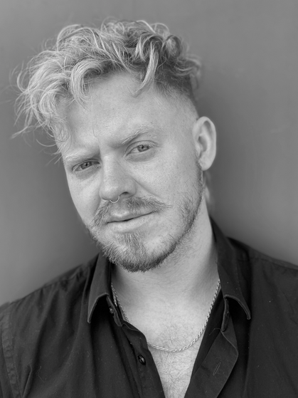 A man with blonde hair and beard wearing black shirt.